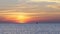 Orange sunrise above the blue sea with swinging slowly buoy