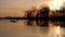 Orange sunrise, lake and fishermen in boats.