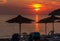 Orange sunset on beach with umbrella. Greece,Limnos.