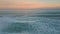 Orange sunset ocean horizon over foamy waves aerial view. Surf rolling coast