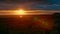 Orange sunset over the sea. Colorful rays of the sun and glare at the moment of sunset or dawn over the city near the