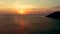 Orange sunset over the sea. The sun is setting over the horizon. Evening view of the mountains and sea. Big Cumulus clouds in the