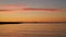 Orange sunset on the sea with a ship on the horizon. Quiet peaceful evening landscape.