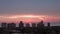 Orange sunset and silhouettes of coastal high rise buildings on the coast of Naples in Florida. aerial zoom shot