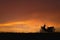 Orange sunset sky. Silhouette motorcycle in sunset landscape backdrop