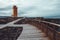 Orange SvÃ¶rtuloft Lighthouse on western part of Iceland on a colorful picturesque backdrop of clouds, lava fields and moss