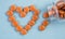 The orange tablets are arranged in the shape of a heart. Vitamins for the heart