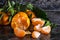 orange tangerines with green leaves on dark background. Peeled mandarin slices