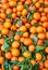 Orange tangerines with leaves lie on a counter in a store top view. Mandarins in the market