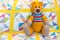 Orange teddy bear sitting on colourful quilted duvet cover