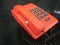 orange telephone on a black background, close-up of the phone