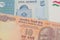 A orange ten rupee bill from India paired with a blue and white five somoni bank note from Tajikistan.
