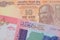 A orange ten rupee bill from India paired with a colorful fifty pound bank note from Sudan.