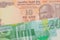 A orange ten rupee bill from India paired with a green and white twenty shekel bank note from Israel.