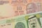 A orange ten rupee bill from India paired with a green and yellow one riyal bank note from Saudi Arabia.
