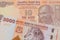 A orange ten rupee bill from India paired with a orange and white 2000 shilling bill from Tanzania.