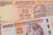 A orange ten rupee bill from India paired with a orange and white 2000 shilling bill from Tanzania.