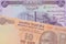 A orange ten rupee bill from India paired with a purple fifty dinar bill from Iraq.