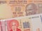 A orange ten rupee bill from India paired with a red and white one lev bank note from Bulgaria.