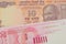 A orange ten rupee bill from India paired with a red and white twenty shekel bill form Israel.