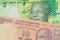 A orange ten rupee bill from India paired with a shiny, green 10 rand bill from South Africa.