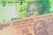 A orange ten rupee bill from India paired with a shiny, green 10 rand bill from South Africa.