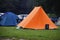 orange tent on the campsite in the rain, concept for a rainy holiday adventure