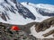 Orange tent on a glacier. Extreme overnight stay in the mountains