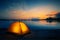 Orange tent on the lake at dusk