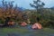 Orange tents in camp under trees