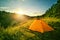 Orange tourist tent on a hill above the ravine