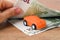 Orange toy car between 100 euro banknotes. Woman hands count paper money. Concept of car buying, renting, service, repair and