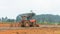 The Orange tractors parked on the street in a construction site.