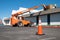 Orange traffic cone in parking lot near hydraulic forklift