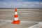 Orange traffic safety cone on an airport runway taxiway