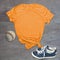 Orange tshirt baseball and shoes still life