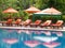 Orange umbrellas and bed at the pool.