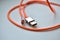 Orange usb cable with silver contacts on white background