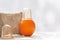 An orange with a vacuum can at the top is on the table against the backdrop of a mesh washcloth made from natural fibers