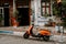 Orange Vespa parked in front of small cozy mediterranean house