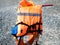 Orange vest hanging over a lifebuoy on a pebble beach on a sunny day