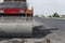 Orange Vibration roller compactor standing on a ground near asphalts road at road construction and repairing asphalt