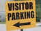 Orange visitor parking sign