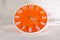 Orange Wall Clock on white blur background.