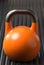 Orange weight training kettlebell on a gym mat