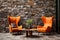 Orange wingback lounge chair and wooden coffee table against wild stone cladding wall