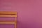 Orange wood bench on vivid pink wall background