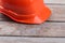 Orange worker`s helmet on the old wooden table.