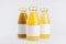 Orange, yellow fruit juices collection in glass bottles with cap, white blank labels, group mock up on white background, template.