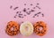 orange and yellow sprinkled donuts on pink background Halloween Space for text